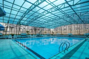 Indoor swimming pool at Hotel Asia International with panoramic windows overlooking Guangzhou skyline